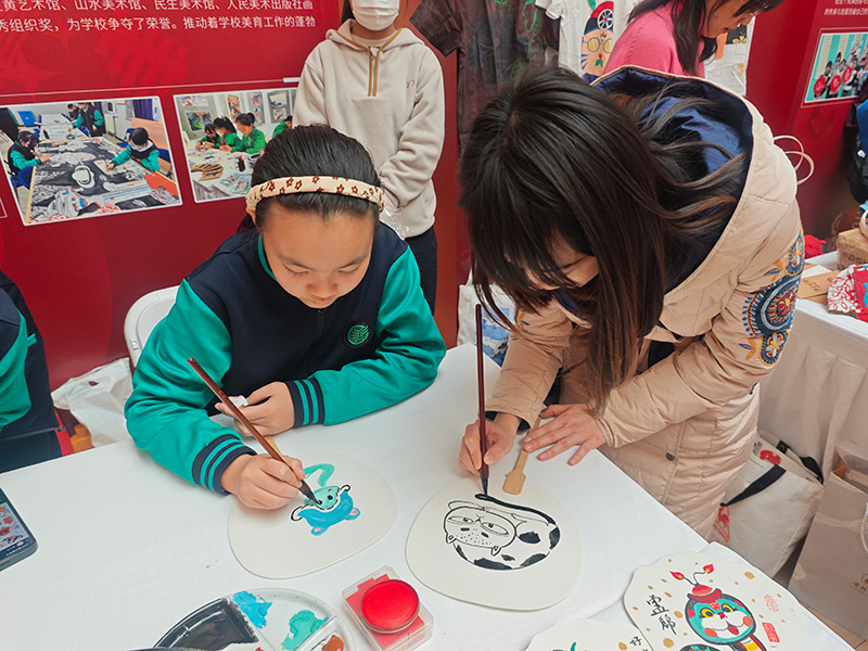 展示活動(dòng)上，學(xué)生和老師一起畫(huà)扇面。人民網(wǎng)記者 郝孟佳攝