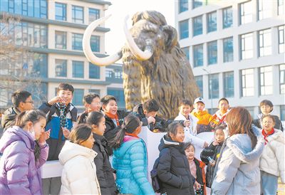 圖為科研人員為學生講解科學家“復活”猛犸象的最新進展。張進剛攝